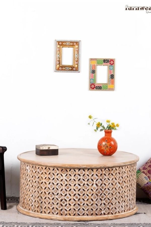 Intricately carved coffee table complements boho furniture ideas in space.