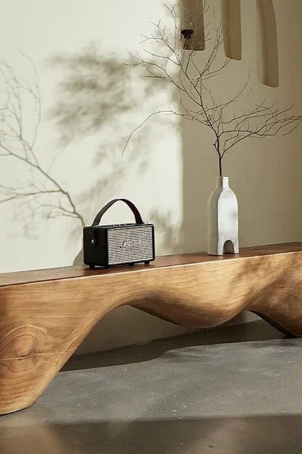 Boho Chic Space: Organic wooden bench, lush plants, vibrant textiles. Boho furniture ideas.