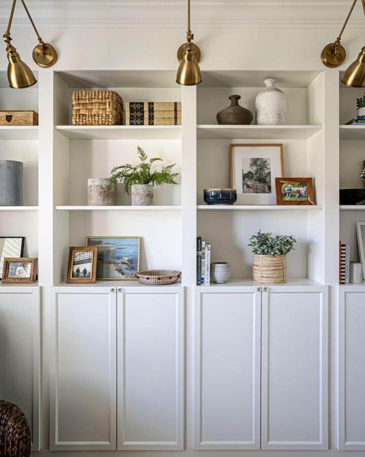 white raised panel cabinetry and open shelving from @thesommerhome decorated with natural elements and framed art pieces