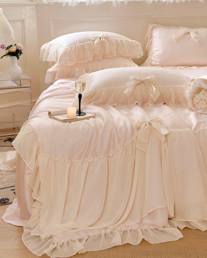 Champagne ruffled bedding set from @vibecoredecor. Romantic cream linens with bow details and layered textures.