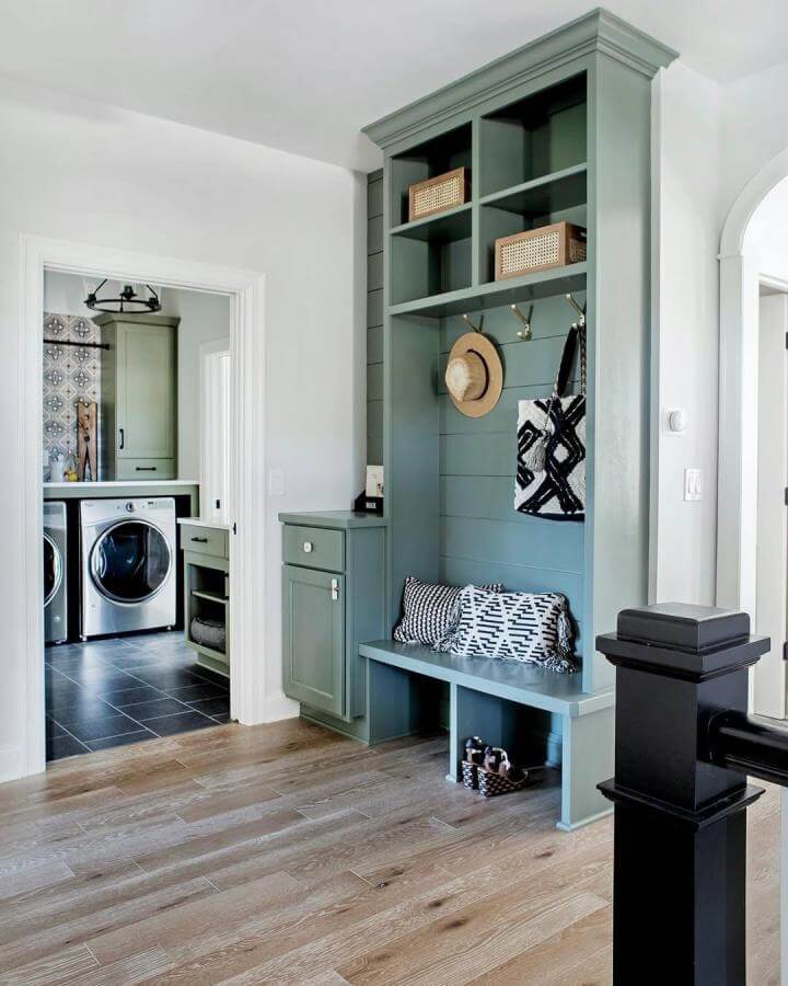 Sage green built-in mudroom bench and storage with shiplap and woven baskets from @memehillstudio showcasing practical, stylish entryway design.
