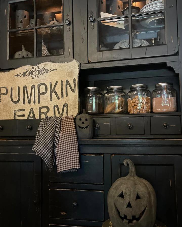 Black painted hutch from @shady_pines3interiors. Mason jars and pumpkin decor create autumn storage display.