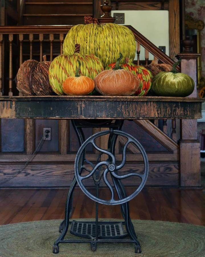 Rustic industrial table from @thefarmhouseproject featuring colorful pumpkins and gourds arranged on weathered wood surface.