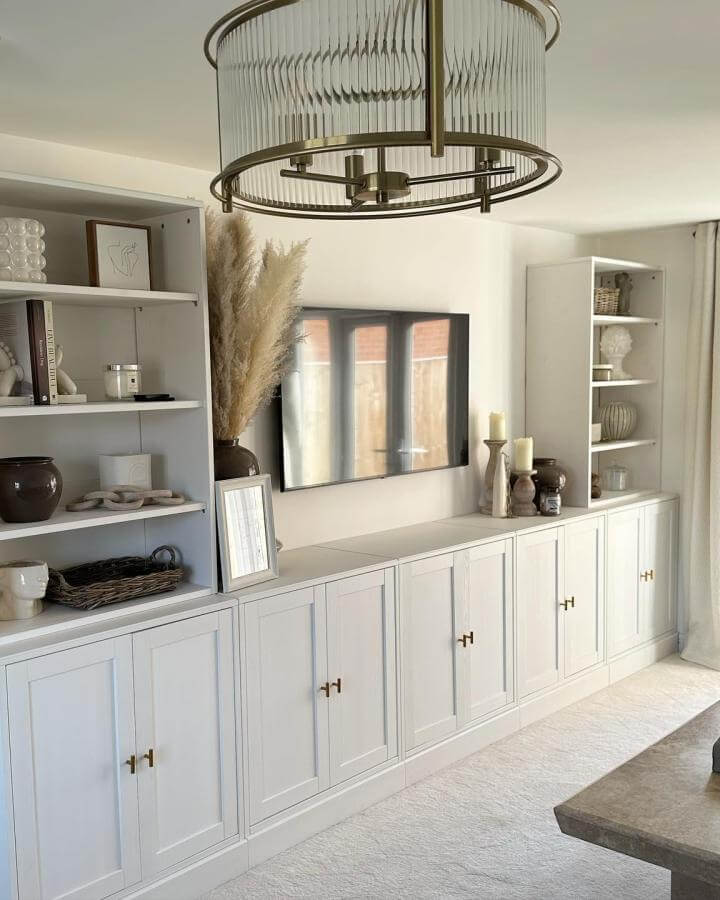 Pale gray cabinet wall from @twentysevenrossdale with brass hardware and mixed shelving display.