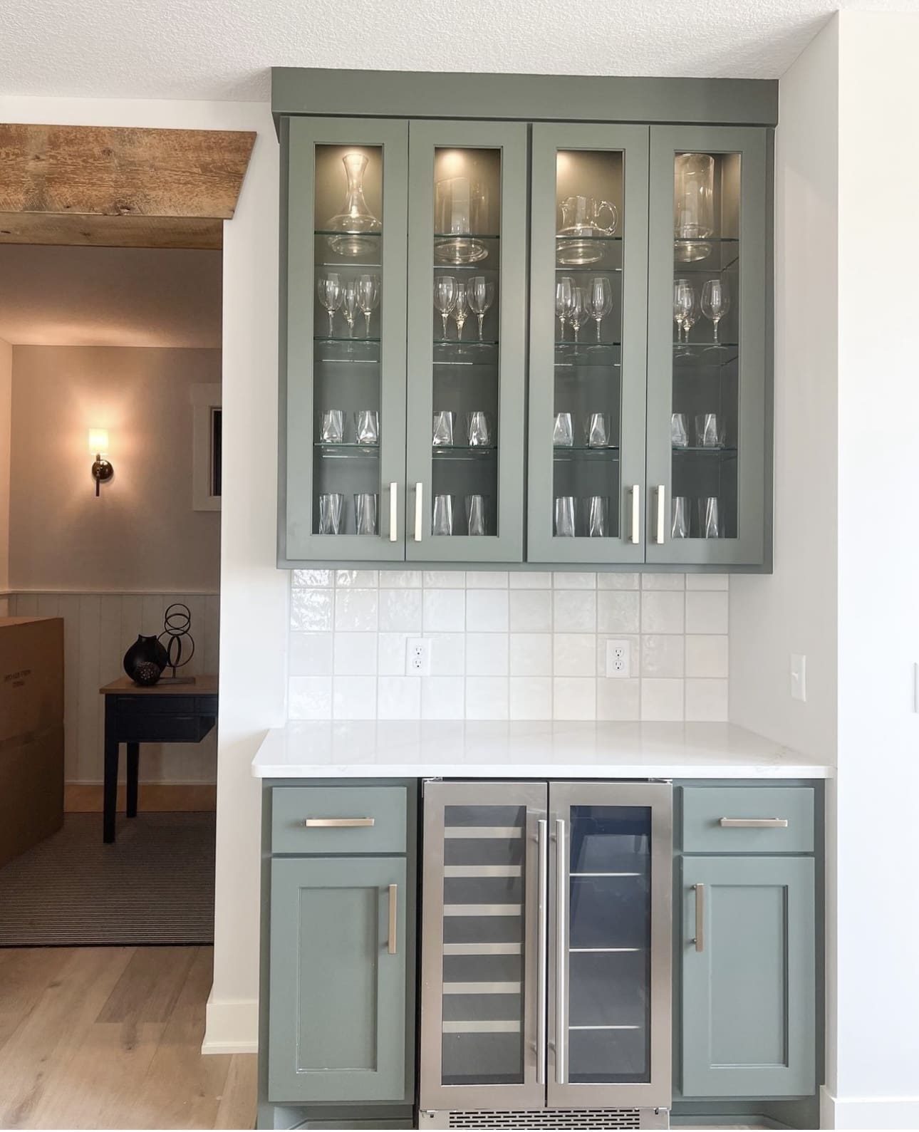 Sage green glass-front cabinets with internal lighting