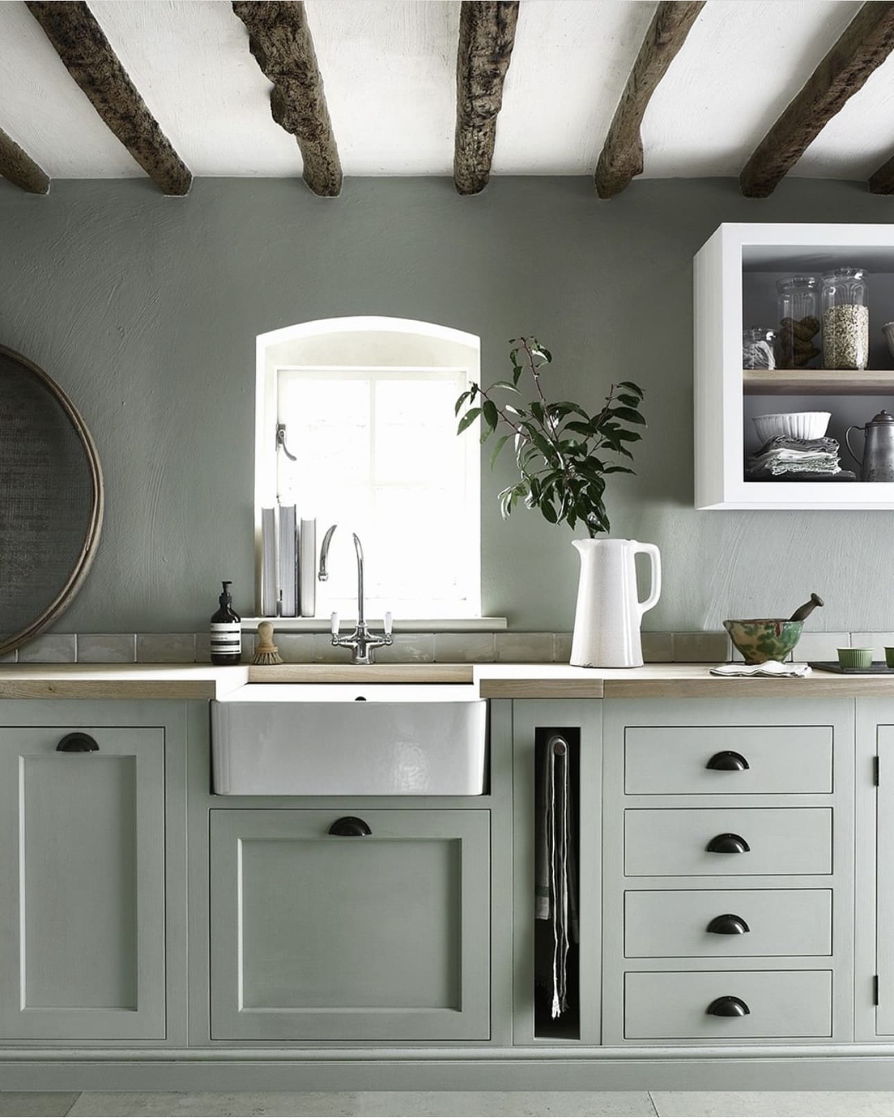Sage green cabinets with a vertical slot for tongs