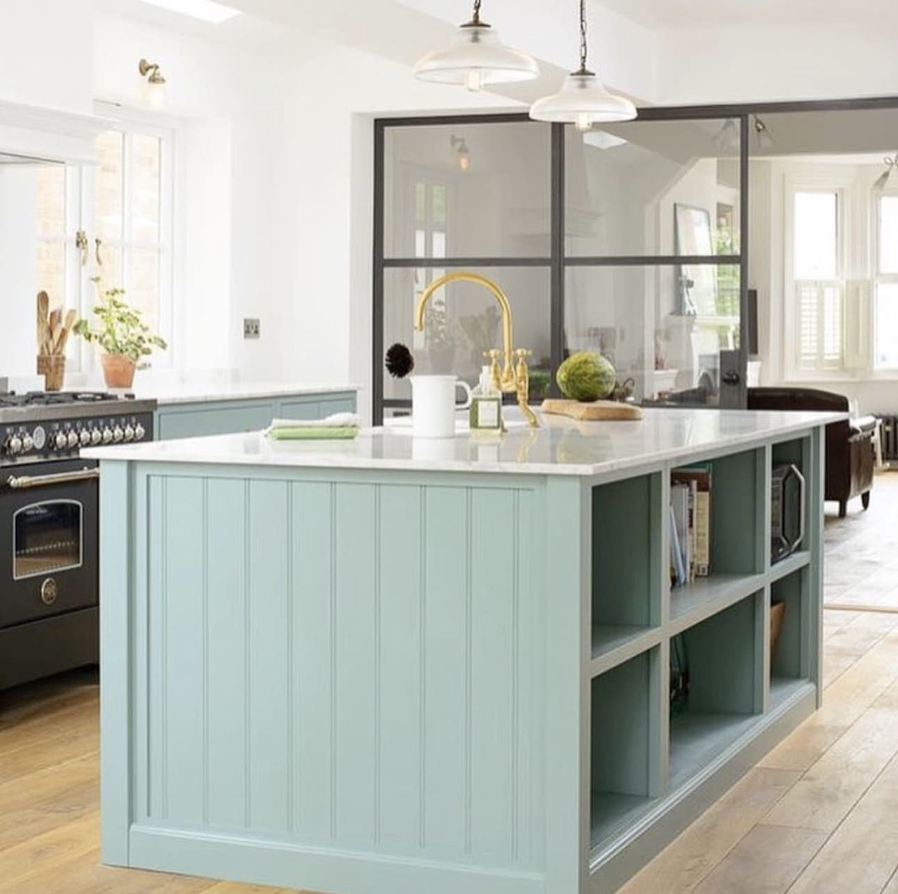 Sage green island with open shelves for books and decor