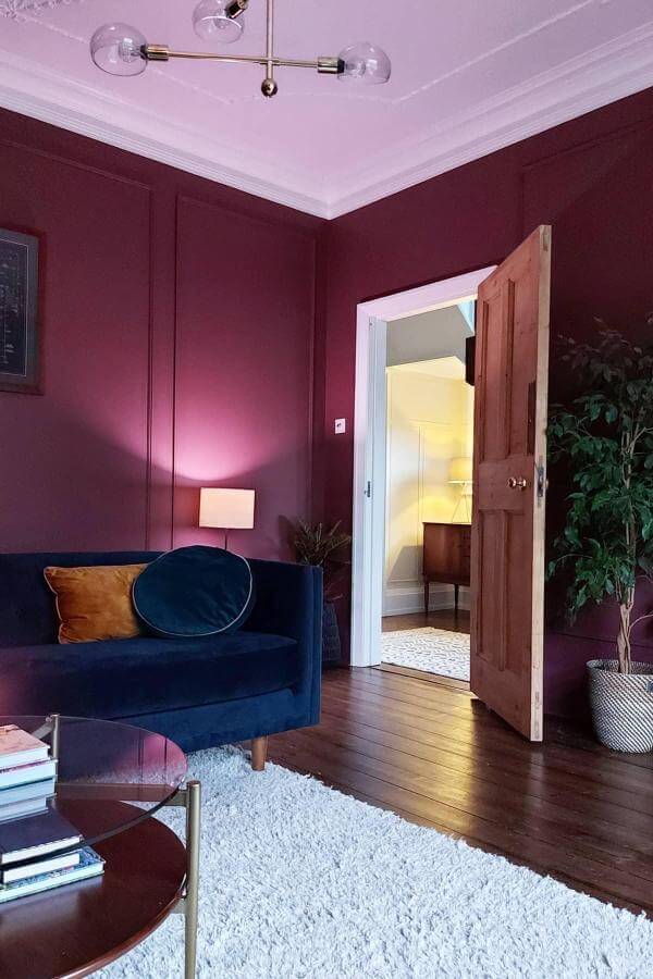 Luxurious aubergine walls with plush accents create a sophisticated ambiance.