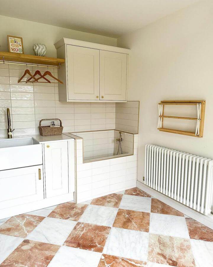 Warm terracotta and white checkerboard tiled mudroom with built-in dog washing station and drying rack by @renovationliving clean and stylish pet care space