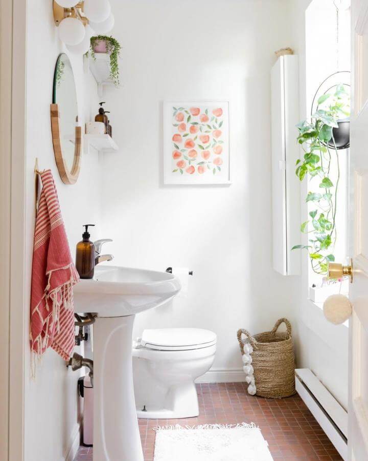 Warm wood framed mirror with cozy textiles and greenery in a compact bathroom by @no179_ showing stylish, textured small space design.