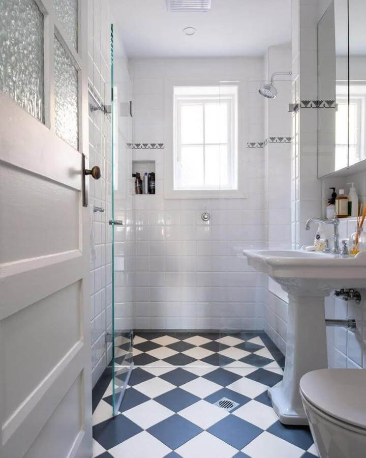 Black and white checkered tile bathroom floor from @omnitubltd with bright white subway tiles and glass shower screen in small bathroom.