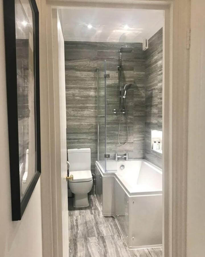 Grey stone-effect tile bathroom with walk-in shower and space-saving bath from @little_edwardian_semi showing smart tiny apartment bathroom ideas.